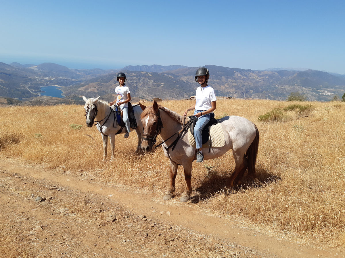 Two girls riding horses in Spain