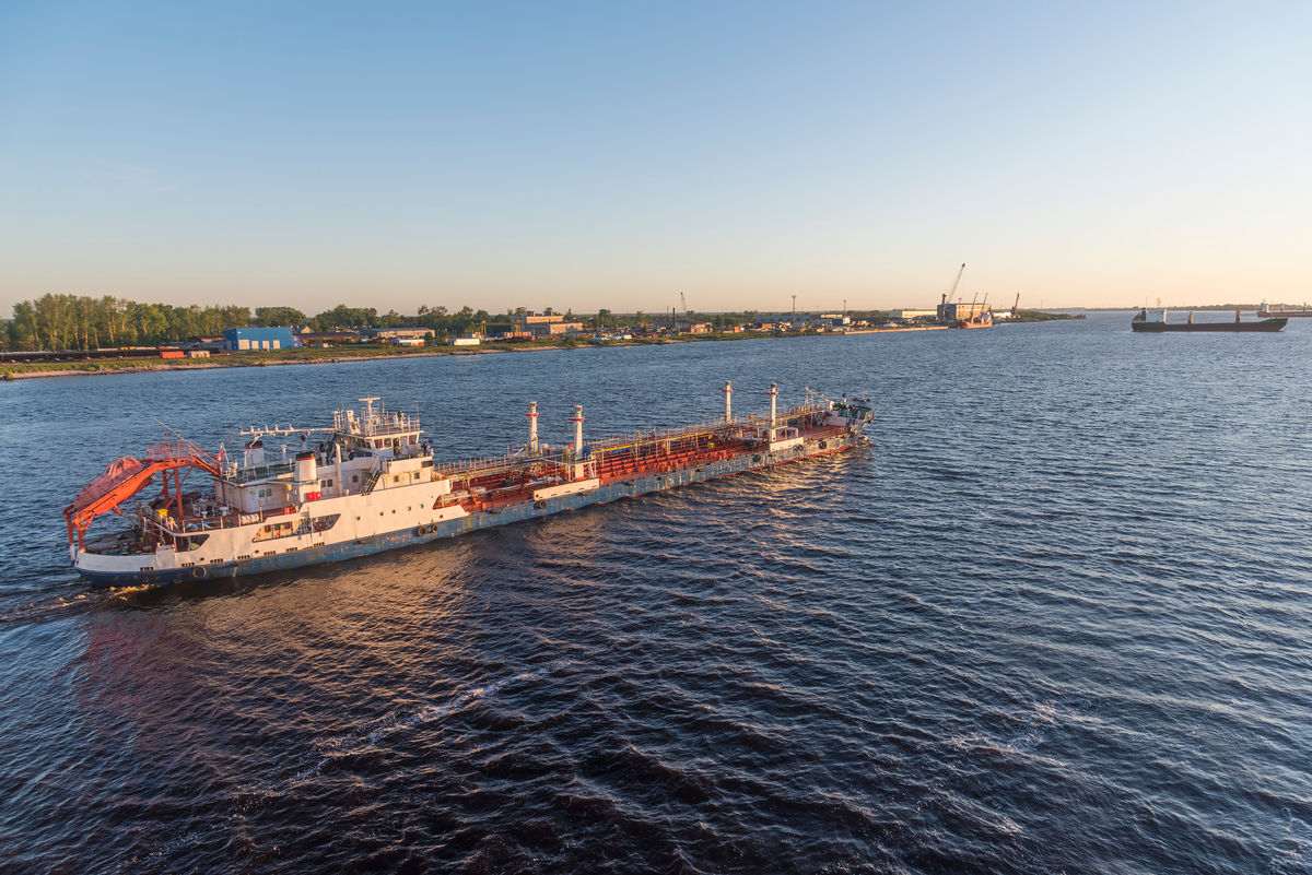 Буксир плывет по широкой реке Северная Двина