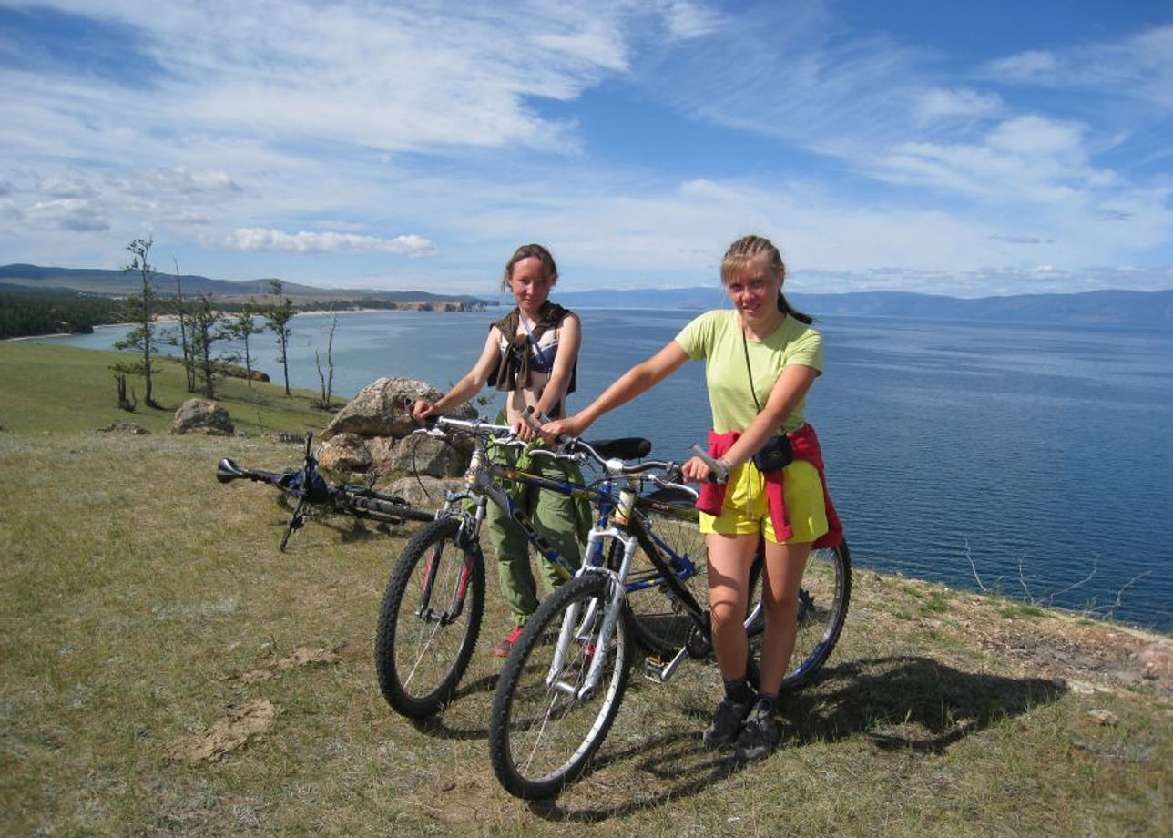 Туристы отдыхают на озере. Горный треккинг Байкал. Путешествие на велосипеде. Поход на велосипеде. Озеро Байкал туризм.