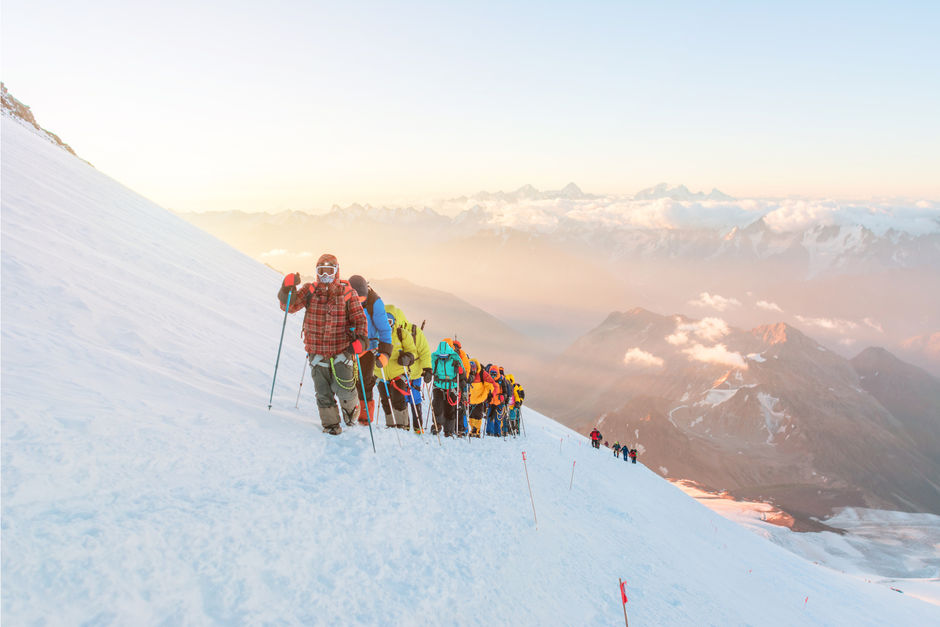Группа альпинистов покоряют вершину